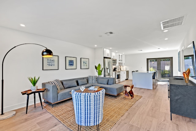 living room featuring light wood-type flooring and french doors