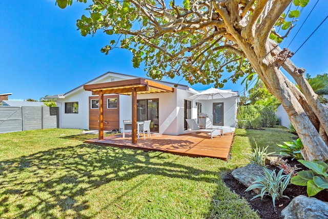 rear view of property featuring a wooden deck and a yard