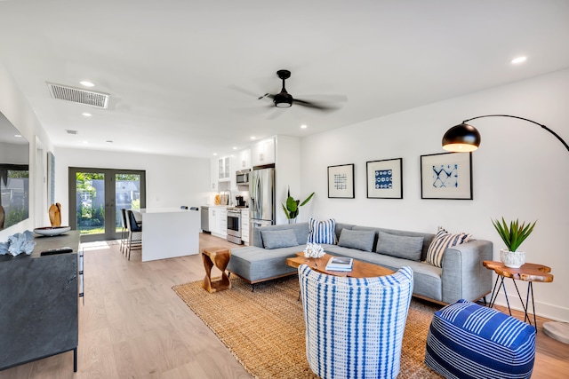 living room featuring ceiling fan and light hardwood / wood-style floors