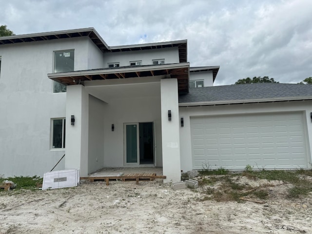 rear view of property featuring a garage