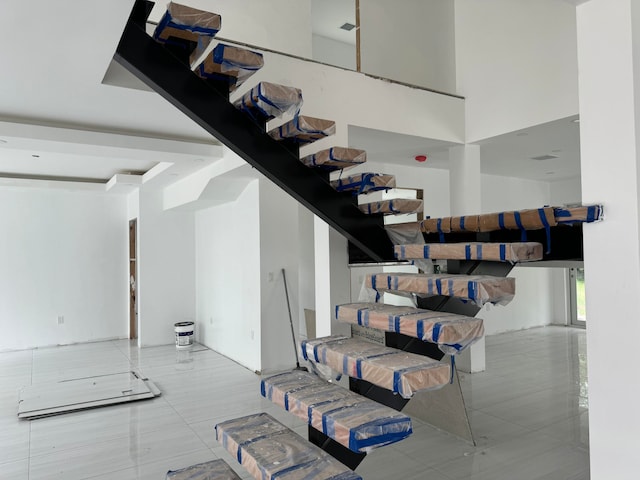 staircase featuring a high ceiling