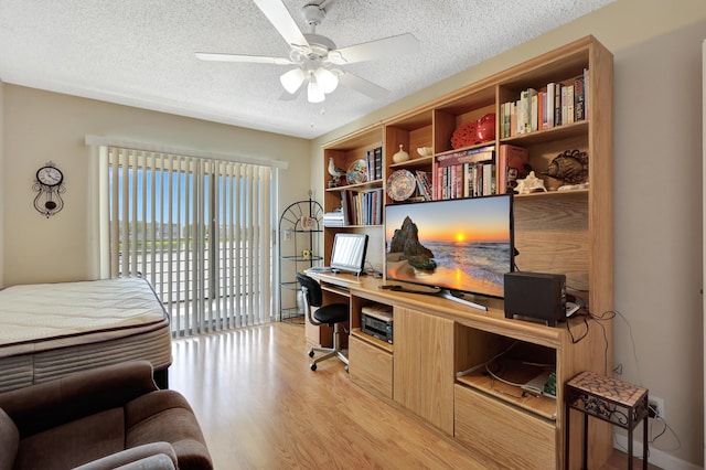 office area featuring ceiling fan, a textured ceiling, and light hardwood / wood-style flooring