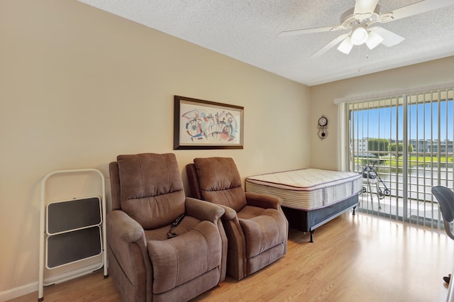 bedroom with a textured ceiling, access to outside, light hardwood / wood-style floors, and ceiling fan