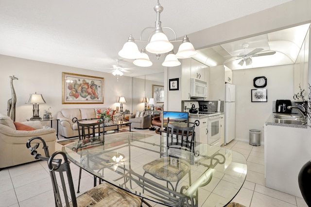 dining area featuring light tile patterned flooring, ceiling fan with notable chandelier, and sink