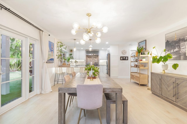 dining area with light hardwood / wood-style floors and a notable chandelier