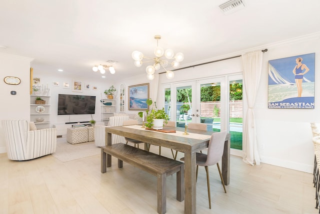 dining room featuring crown molding, french doors, and an inviting chandelier