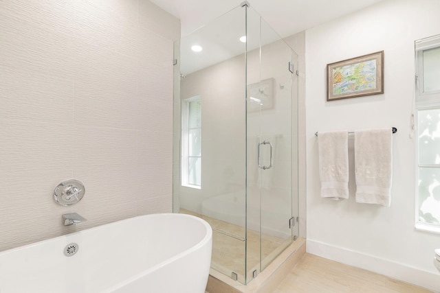 bathroom featuring shower with separate bathtub