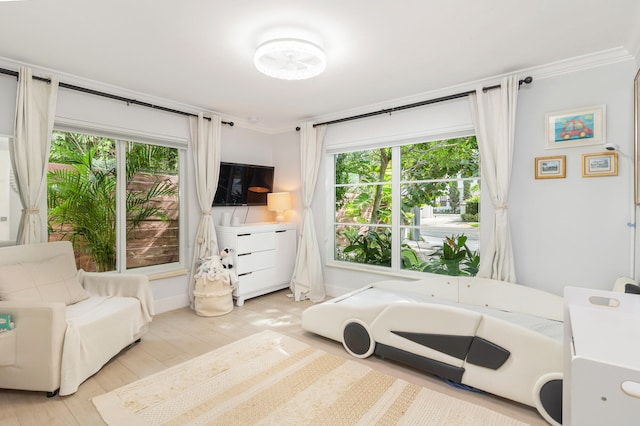 bedroom featuring crown molding, light hardwood / wood-style floors, and multiple windows