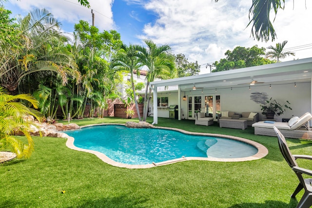 view of pool featuring an outdoor hangout area, a patio area, grilling area, and a yard