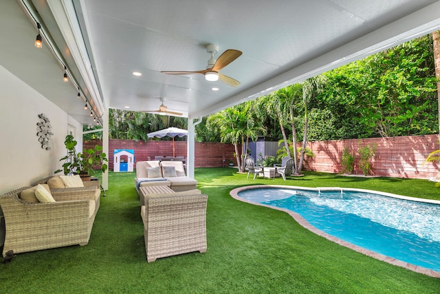 view of pool featuring ceiling fan, pool water feature, a yard, and an outdoor hangout area