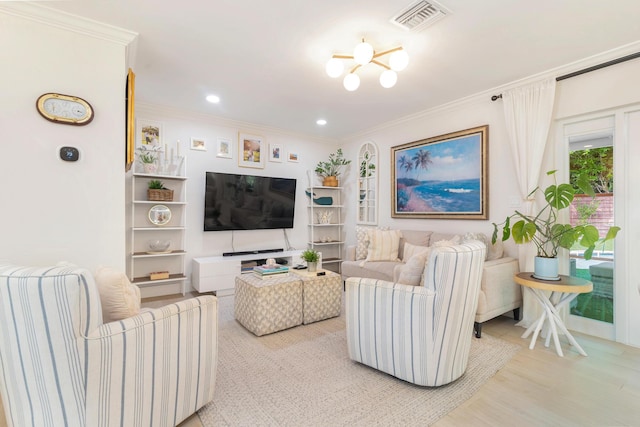 living room with crown molding, a chandelier, and light hardwood / wood-style flooring