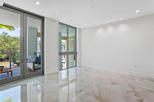 empty room featuring a wall of windows and french doors