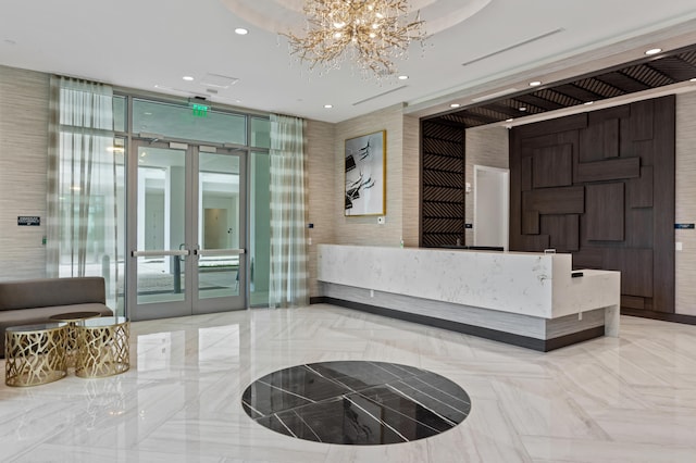 welcome area with french doors and an inviting chandelier