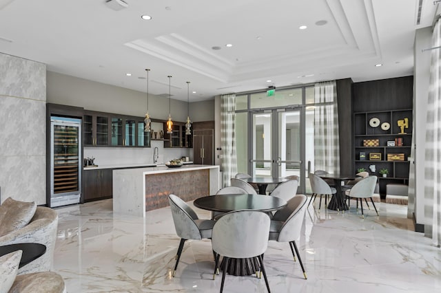 dining room featuring sink, wine cooler, a tray ceiling, and french doors