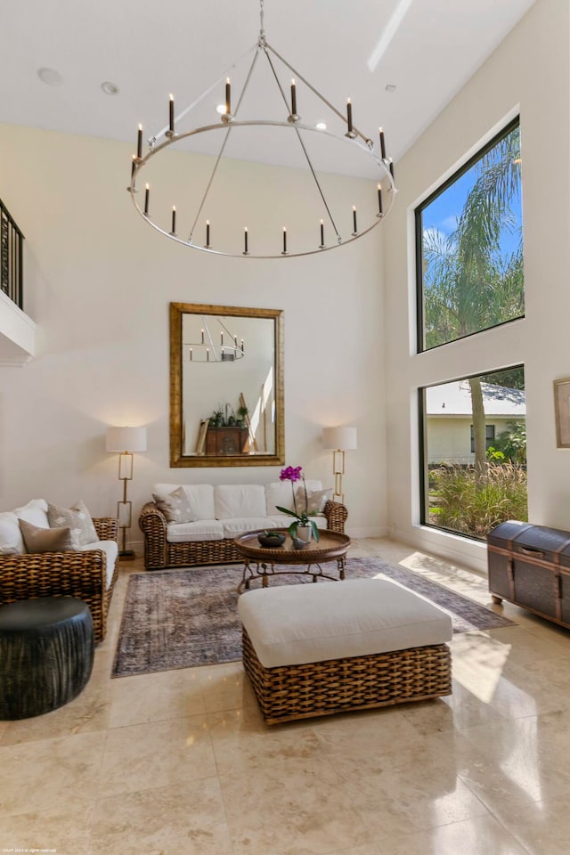 living room featuring a notable chandelier, a towering ceiling, and a wealth of natural light