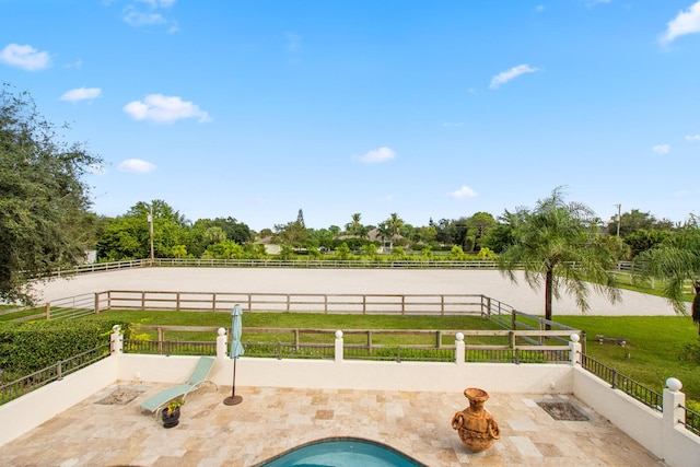 view of swimming pool featuring a patio, a water view, and a yard