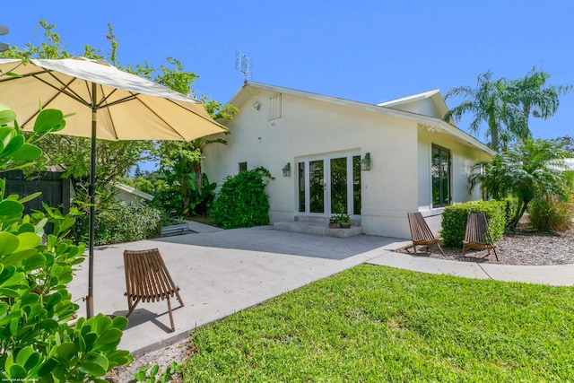 rear view of house featuring a lawn and a patio area