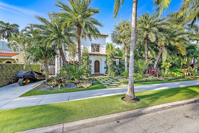 mediterranean / spanish home featuring a front lawn