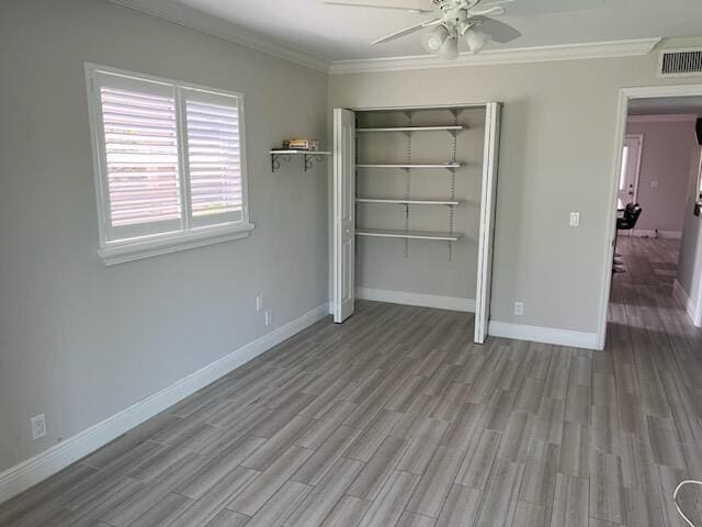 unfurnished bedroom with ceiling fan, ornamental molding, light wood-type flooring, and a closet