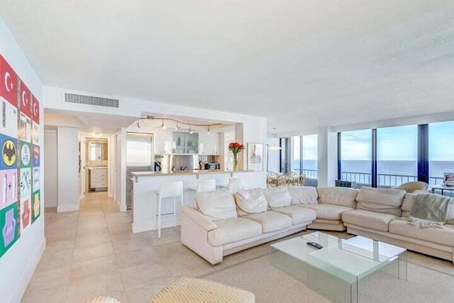 tiled living room featuring a water view