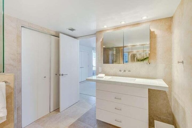 bathroom featuring vanity, tile walls, and tile patterned flooring