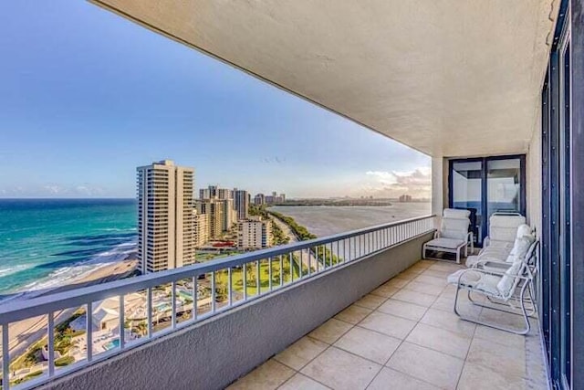 balcony featuring a water view and a view of the beach