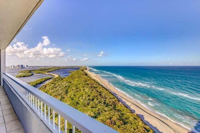 balcony featuring a view of the beach and a water view