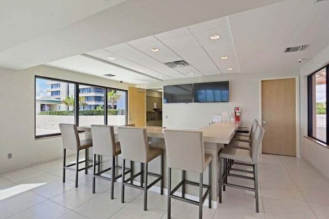 kitchen with a kitchen breakfast bar, kitchen peninsula, a healthy amount of sunlight, and light tile patterned flooring