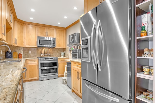 kitchen with light stone counters, light tile patterned flooring, sink, decorative backsplash, and appliances with stainless steel finishes