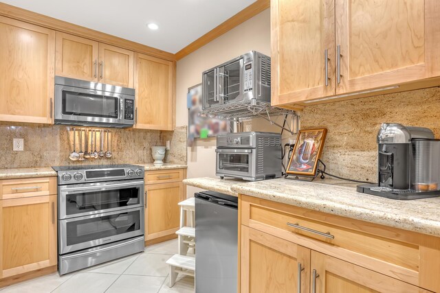 kitchen with light stone countertops, light tile patterned flooring, stainless steel appliances, and tasteful backsplash