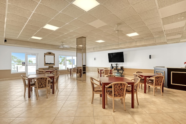 dining room with ceiling fan, light tile patterned flooring, and a paneled ceiling