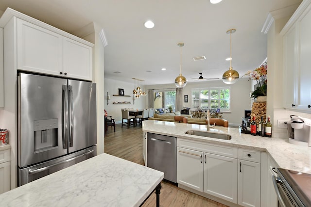 kitchen featuring ceiling fan, hanging light fixtures, sink, white cabinetry, and stainless steel appliances