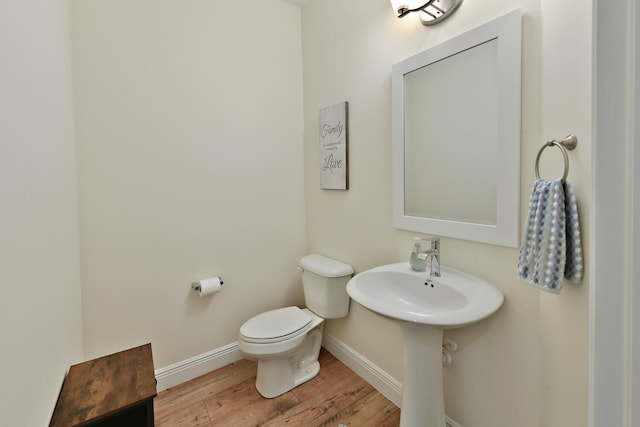 bathroom featuring wood-type flooring and toilet