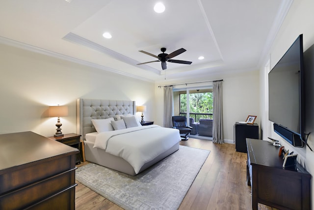 bedroom with light hardwood / wood-style floors, crown molding, a tray ceiling, ceiling fan, and access to outside