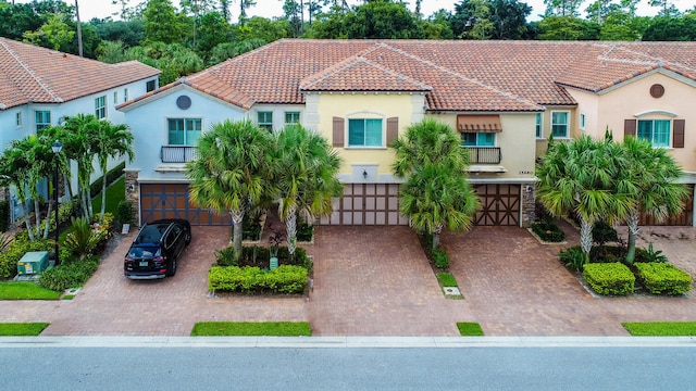 mediterranean / spanish-style home featuring a balcony and a garage