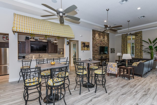 dining room featuring ornamental molding, ceiling fan, and light hardwood / wood-style flooring