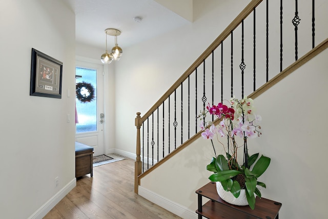 entryway with an inviting chandelier and light hardwood / wood-style flooring