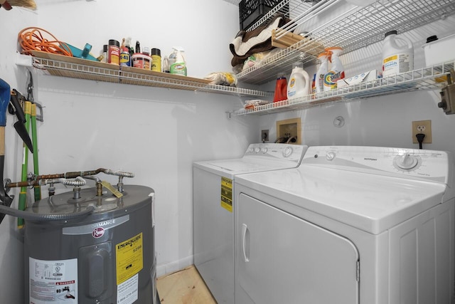 clothes washing area featuring washing machine and dryer and water heater