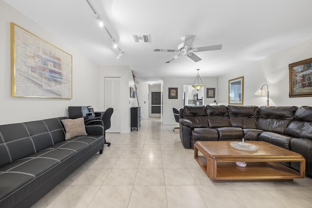 living room featuring track lighting, ceiling fan, and light tile patterned floors