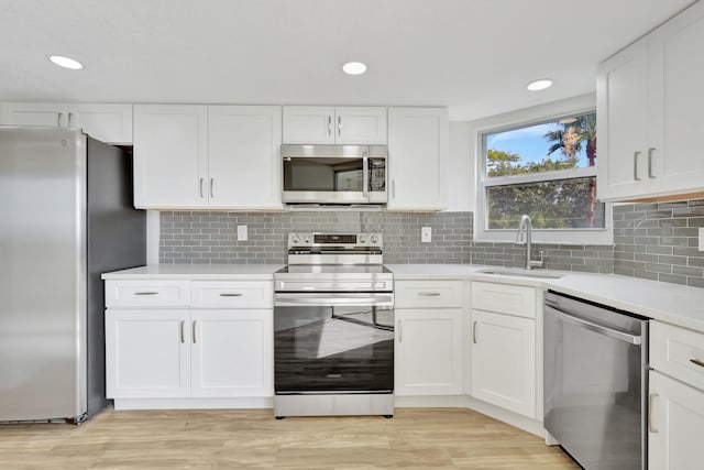 kitchen featuring white cabinets, appliances with stainless steel finishes, and light wood-type flooring