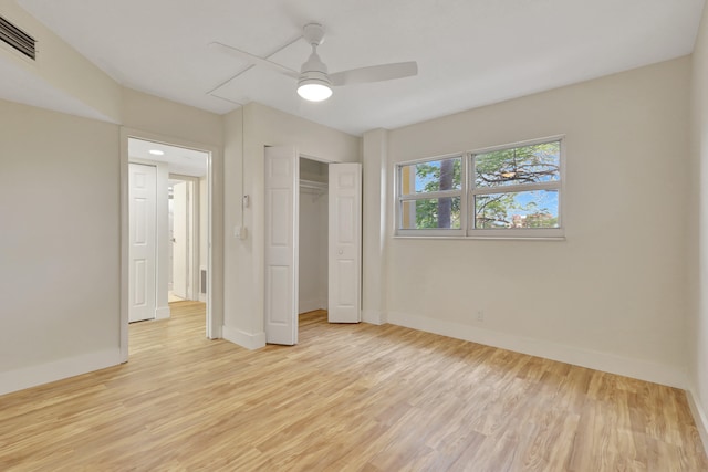 unfurnished bedroom featuring ceiling fan, light wood-type flooring, and a closet