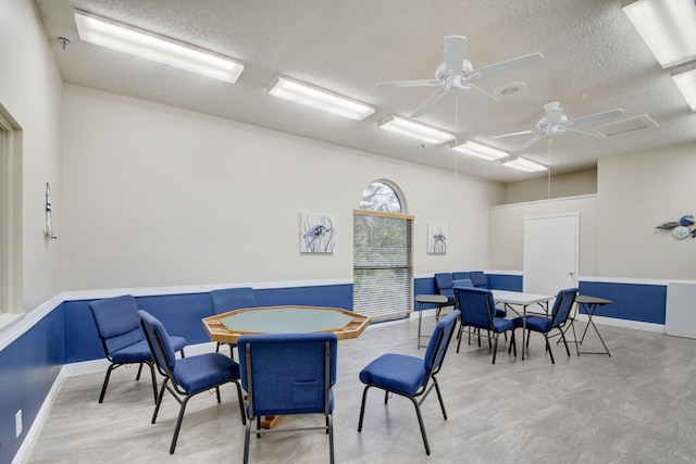 dining space with ceiling fan and a textured ceiling