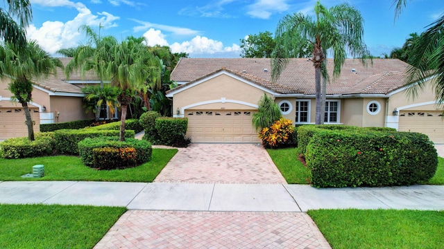 ranch-style home featuring a garage and a front lawn