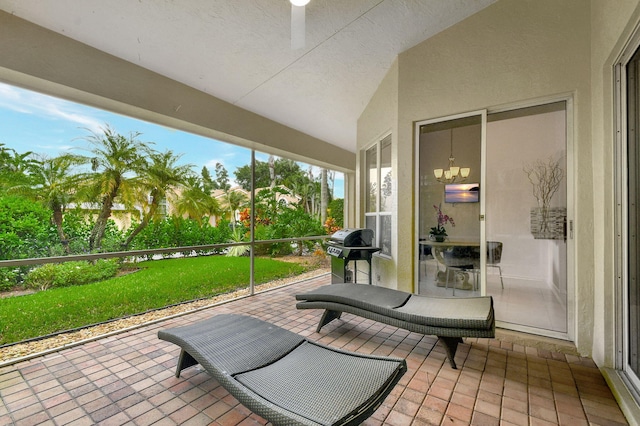 sunroom / solarium featuring a notable chandelier and vaulted ceiling