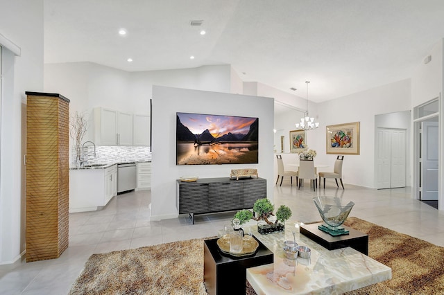 tiled living room featuring an inviting chandelier, sink, and high vaulted ceiling