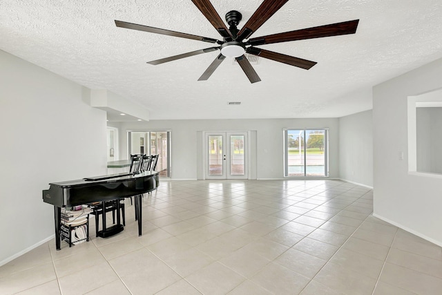 living room featuring french doors, light tile patterned floors, ceiling fan, and a textured ceiling