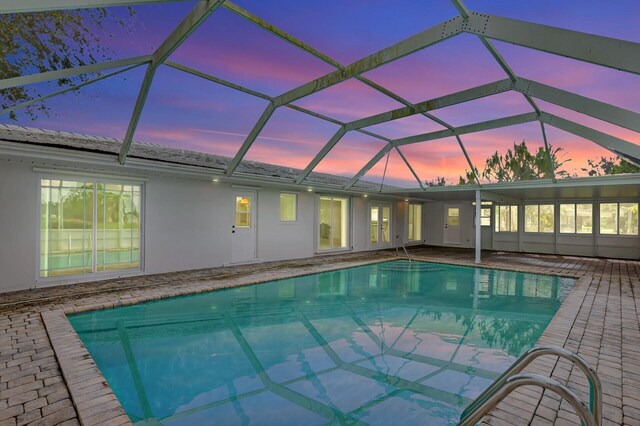 view of swimming pool featuring a lanai and a patio