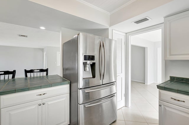 kitchen featuring tile counters, white cabinets, stainless steel fridge with ice dispenser, and light tile patterned floors