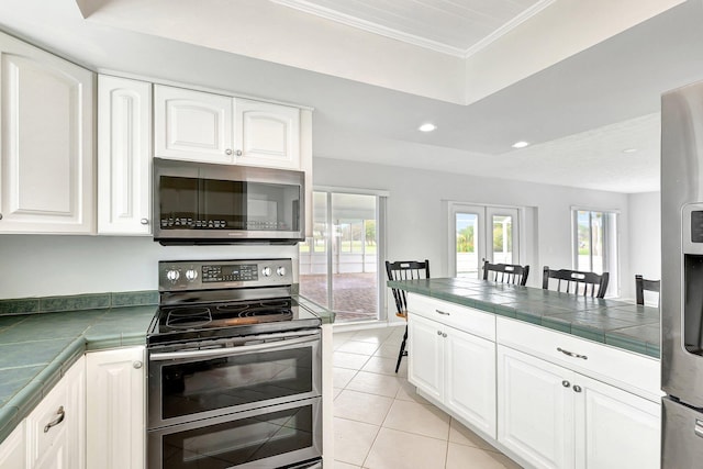 kitchen featuring stainless steel appliances, white cabinets, and light tile patterned floors