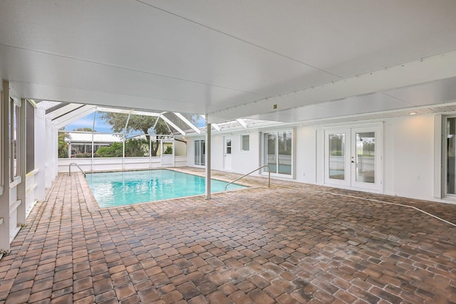 outdoor pool with french doors, glass enclosure, and a patio